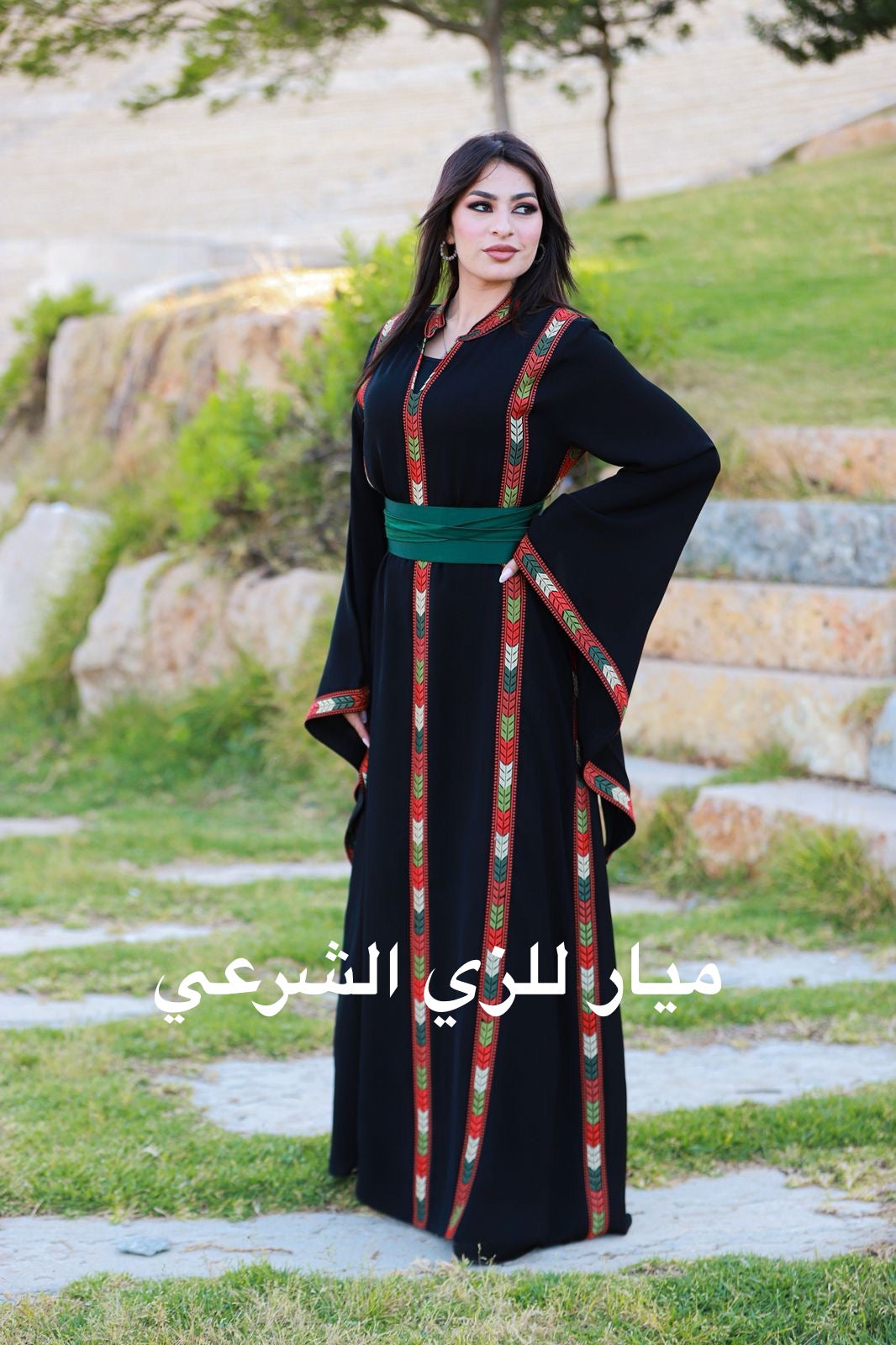 Black dress with tatreez details and satin belt.