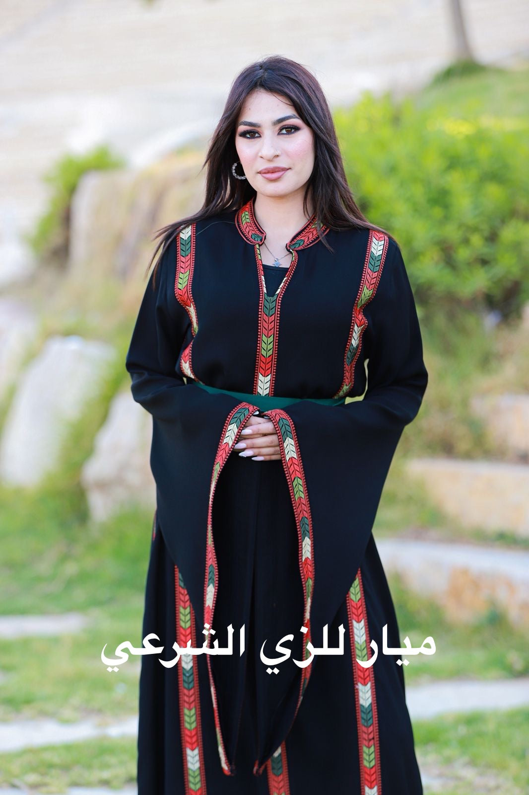 Black dress with tatreez details and satin belt.
