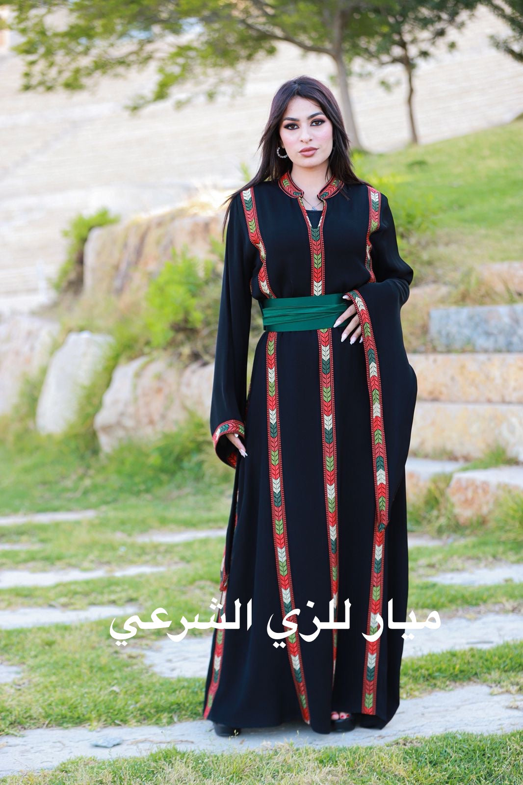 Black dress with tatreez details and satin belt.