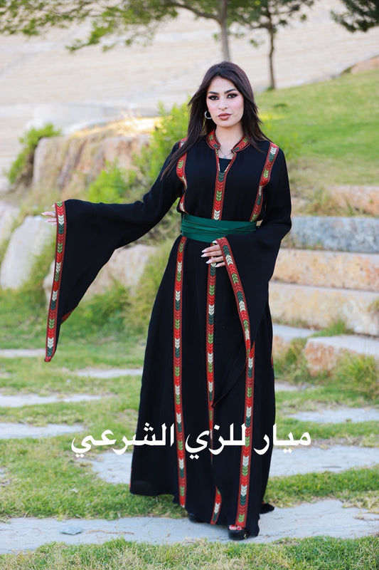 Black dress with tatreez details and satin belt.