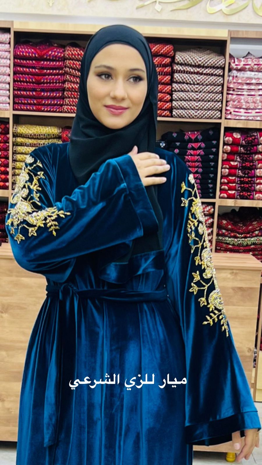 Blue velvet abaya with details on the sleeves.