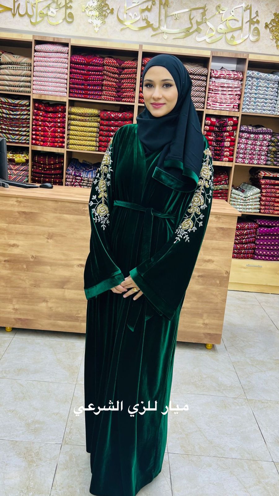 Green velvet abaya with details on the sleeves.