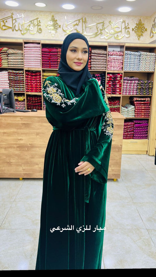 Green velvet abaya with details on the sleeves.