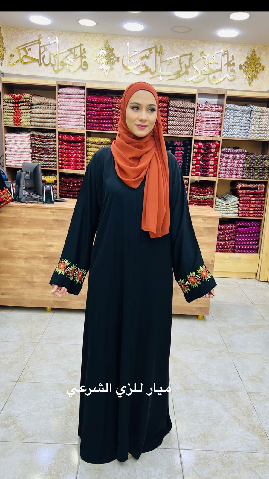 Black abaya with cute orange flowers details on the sleeve.